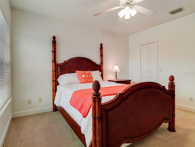 bedroom with light colored carpet, a closet, and ceiling fan