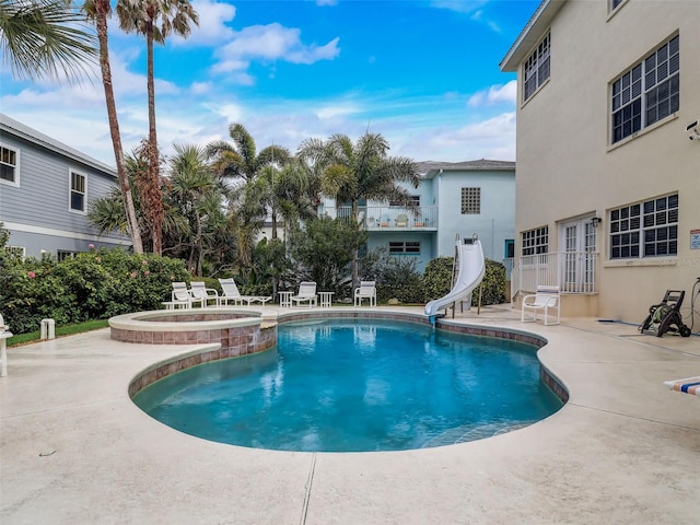 view of pool featuring a water slide and a patio area