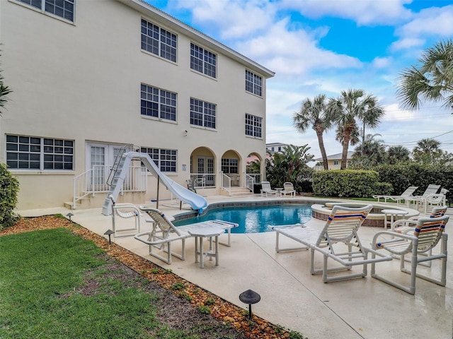 view of pool featuring a water slide, a patio area, and french doors