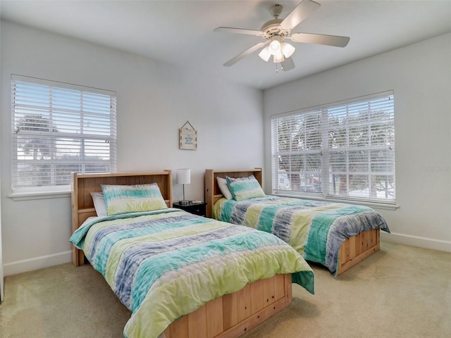 carpeted bedroom with ceiling fan and multiple windows