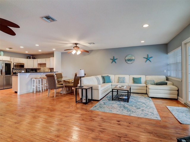 living room featuring ceiling fan and light wood-type flooring
