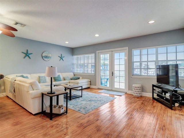 living room with french doors, ceiling fan, and light wood-type flooring