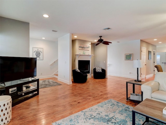 living room with ceiling fan and light wood-type flooring