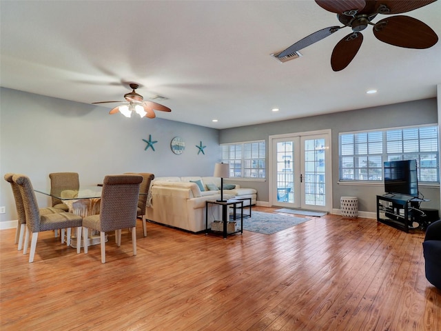 living room featuring french doors, ceiling fan, and light wood-type flooring