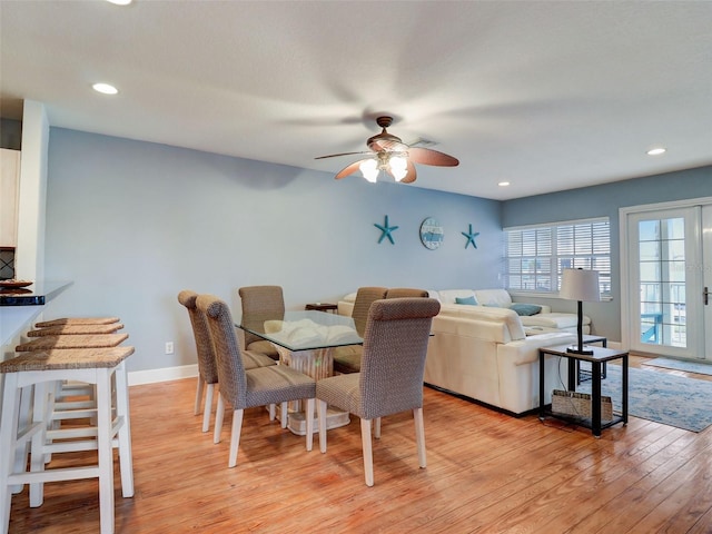dining area with ceiling fan, light wood-type flooring, and french doors