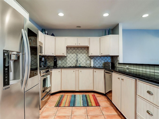 kitchen featuring light tile floors, appliances with stainless steel finishes, backsplash, and sink