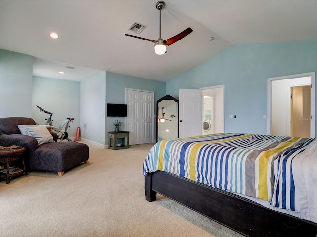 bedroom with vaulted ceiling, ceiling fan, a closet, washer / dryer, and light carpet