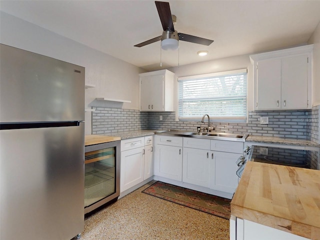 kitchen featuring tasteful backsplash, stainless steel fridge, white cabinets, and wine cooler