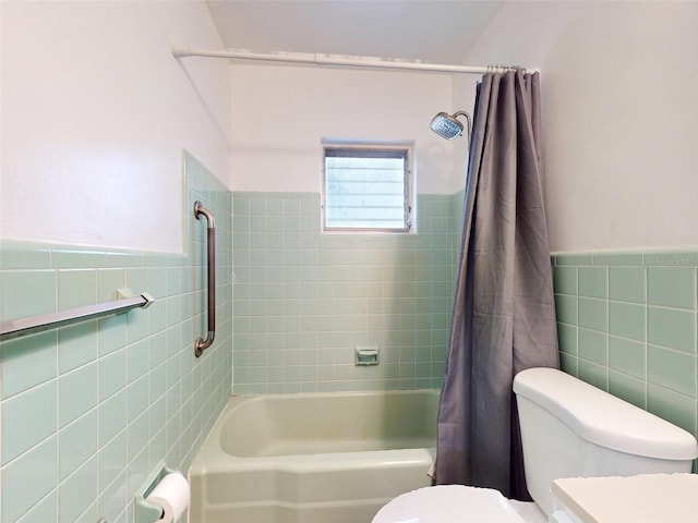 bathroom featuring shower / bath combo, toilet, and tile walls