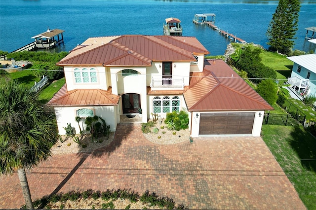 mediterranean / spanish-style house featuring a water view, a garage, and a balcony