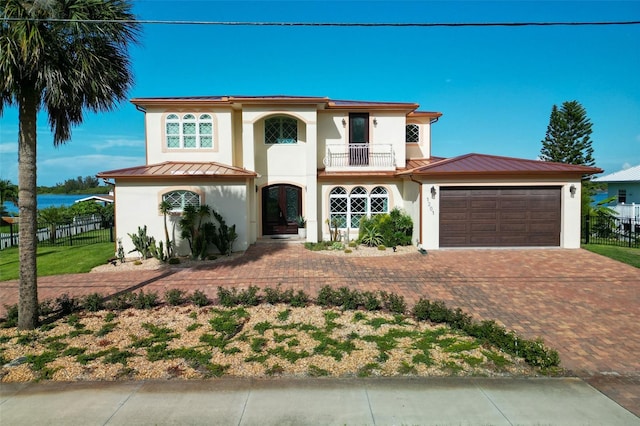 mediterranean / spanish-style home featuring a garage and a balcony