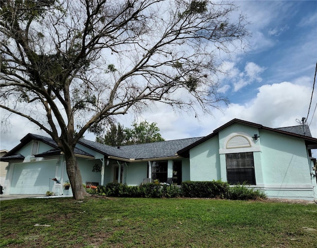 view of side of property with stucco siding, a garage, and a lawn