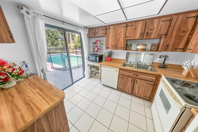 kitchen with white appliances, sink, and light tile patterned floors