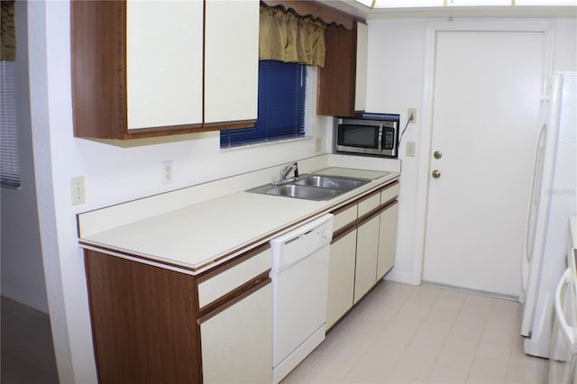 kitchen with dishwasher, sink, and white cabinets