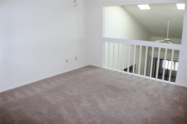 carpeted spare room with ceiling fan and vaulted ceiling