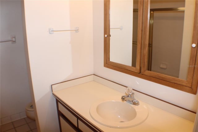 bathroom featuring vanity, tile patterned floors, and toilet