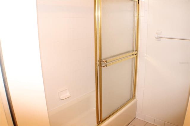 bathroom featuring bath / shower combo with glass door