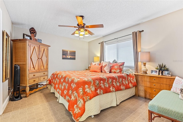 bedroom with a textured ceiling, light colored carpet, and ceiling fan