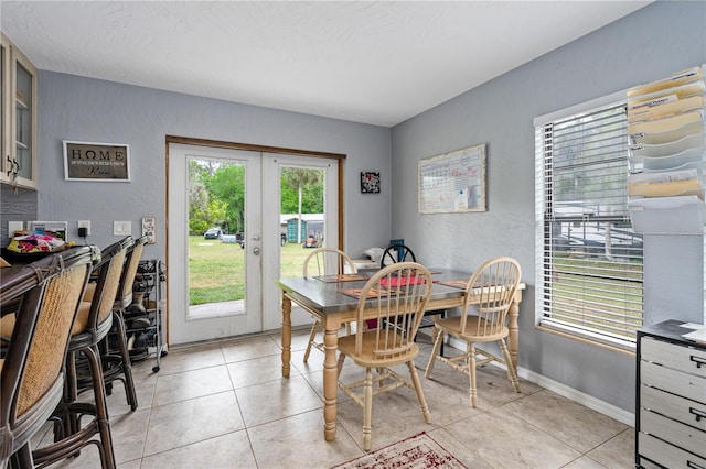 dining room with light tile patterned floors, a textured ceiling, and french doors