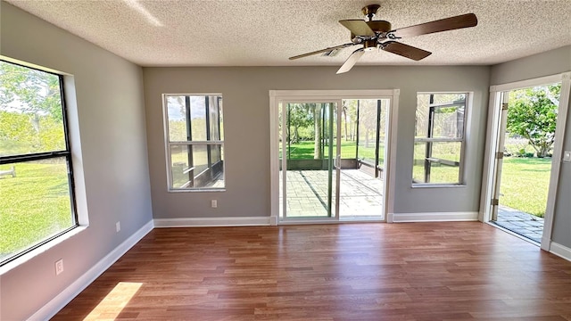 doorway with hardwood / wood-style floors, ceiling fan, and a textured ceiling