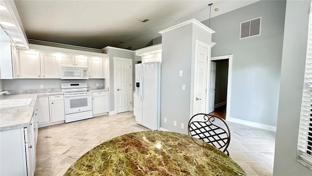 kitchen with white cabinets, white appliances, lofted ceiling, and sink