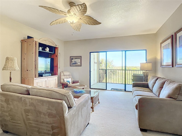 carpeted living room with a textured ceiling and ceiling fan