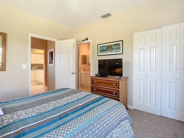 carpeted bedroom featuring connected bathroom, a closet, and ceiling fan