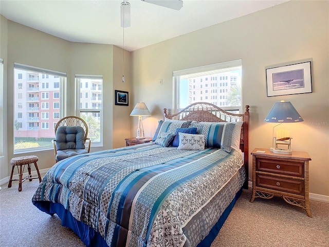 carpeted bedroom featuring multiple windows and ceiling fan