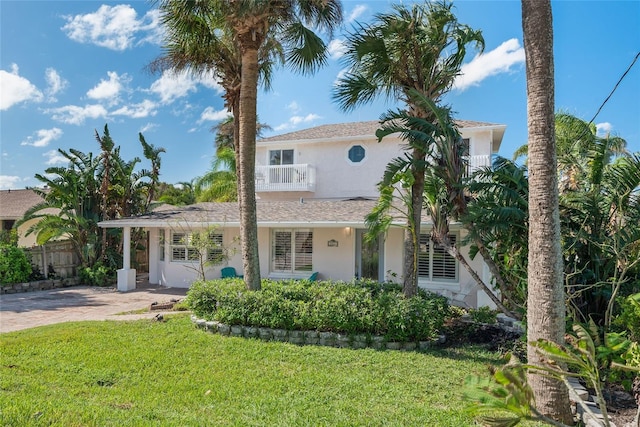 view of front of property with a porch, a front yard, and a balcony