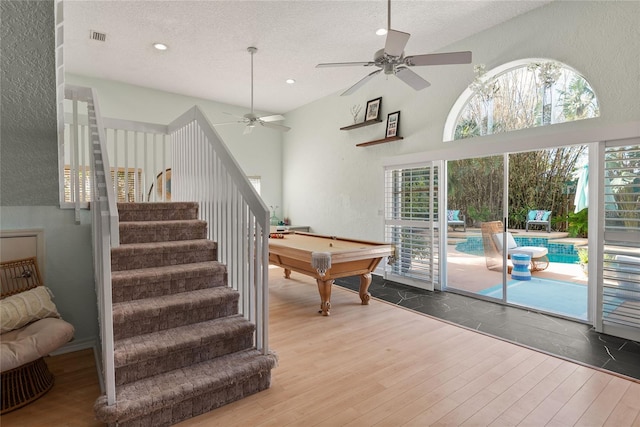 rec room featuring a high ceiling, wood-type flooring, billiards, a textured ceiling, and ceiling fan