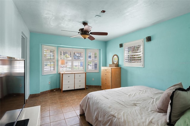 tiled bedroom featuring ceiling fan