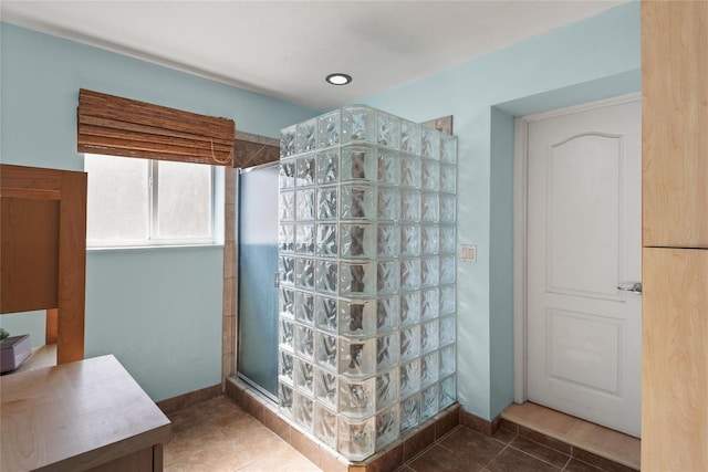 bathroom with a tile shower and tile patterned flooring