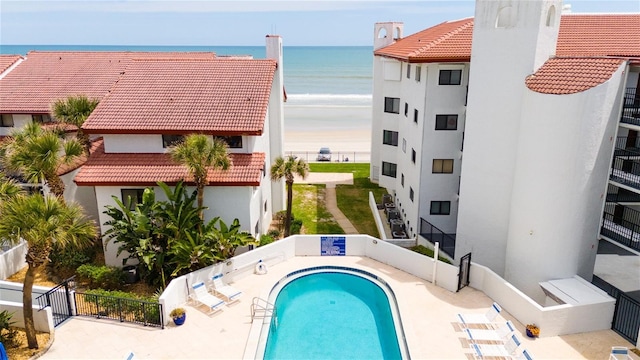 view of swimming pool featuring a water view and a patio area