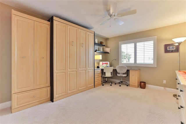 carpeted home office featuring ceiling fan