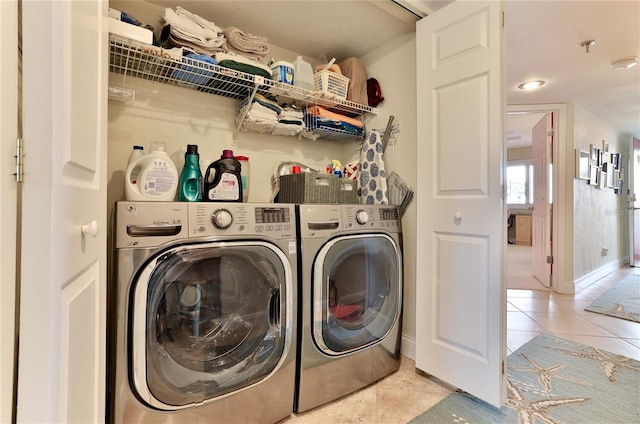 laundry area with light tile patterned flooring and washing machine and dryer