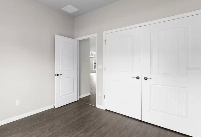 unfurnished bedroom featuring dark hardwood / wood-style floors and a closet