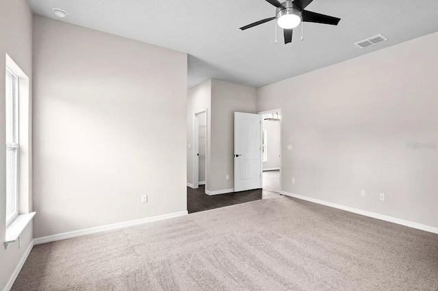 interior space with ceiling fan and dark carpet