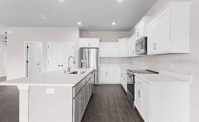 kitchen featuring an island with sink, dark wood-type flooring, sink, white cabinets, and appliances with stainless steel finishes