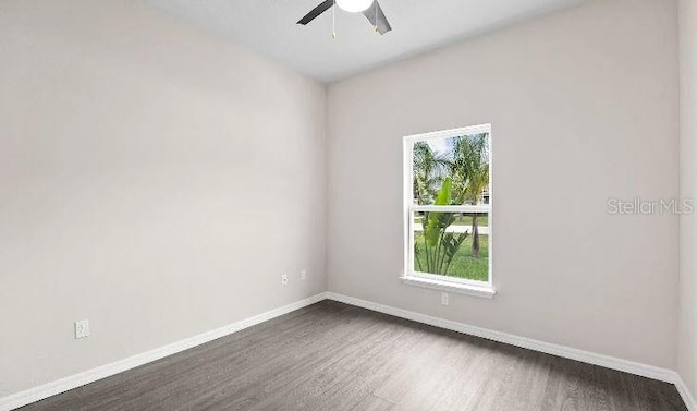 unfurnished room with dark hardwood / wood-style flooring and ceiling fan