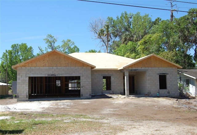 property under construction with concrete block siding and a garage