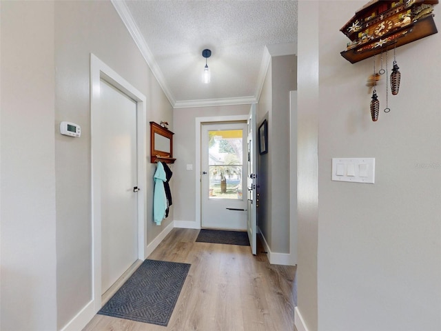 entryway with crown molding, a textured ceiling, and light wood-type flooring