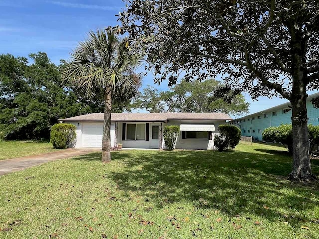 ranch-style house featuring a garage and a front lawn