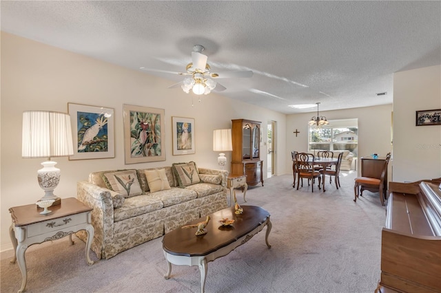 carpeted living room featuring ceiling fan and a textured ceiling