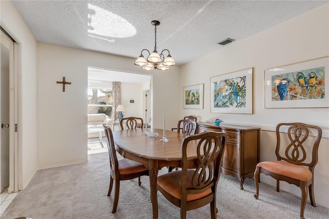 carpeted dining space featuring a notable chandelier and a textured ceiling