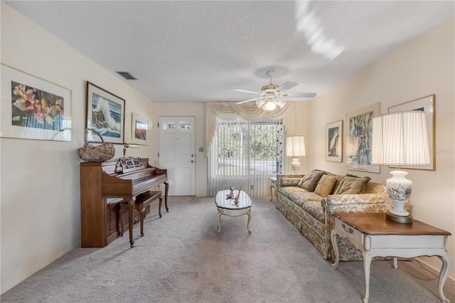 carpeted living room featuring a textured ceiling and ceiling fan