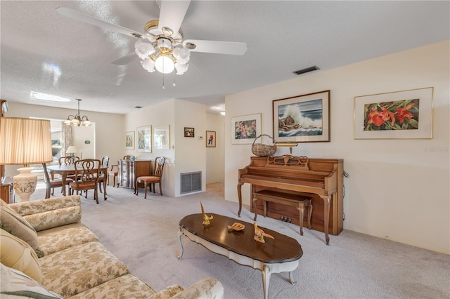 carpeted living room with ceiling fan with notable chandelier and a textured ceiling