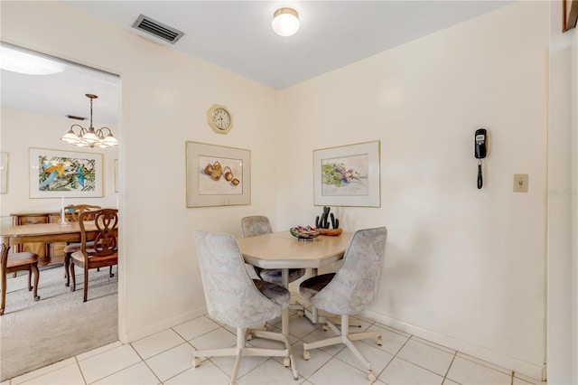 tiled dining room with an inviting chandelier