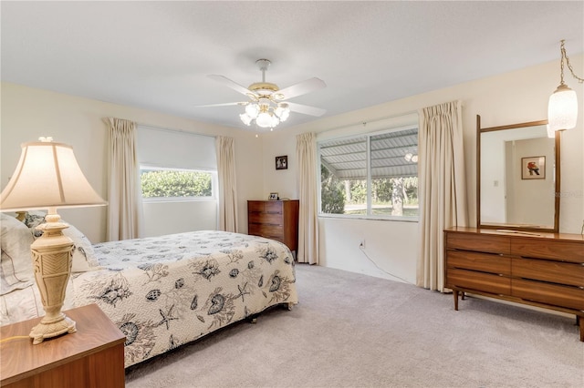 carpeted bedroom featuring ceiling fan and multiple windows