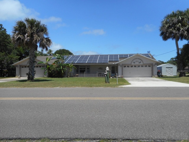 single story home with a garage, a front lawn, and solar panels