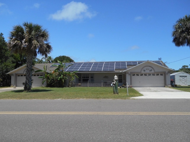 ranch-style home with a garage, solar panels, and a front lawn